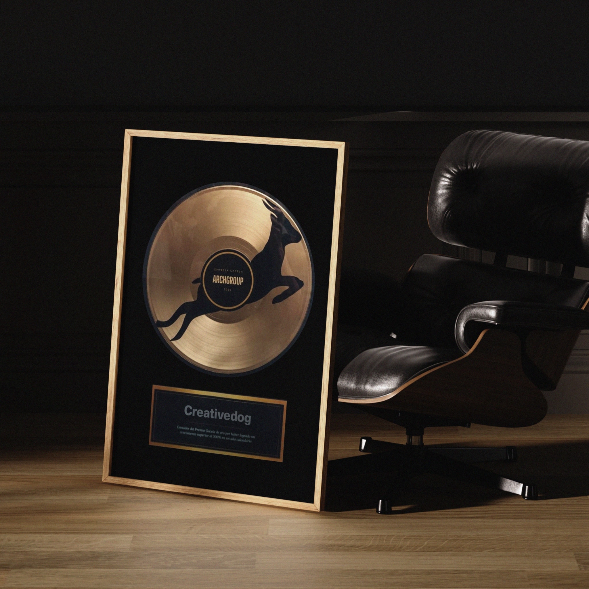 A framed gold record with a Creativedog plaque, beside a leather armchair