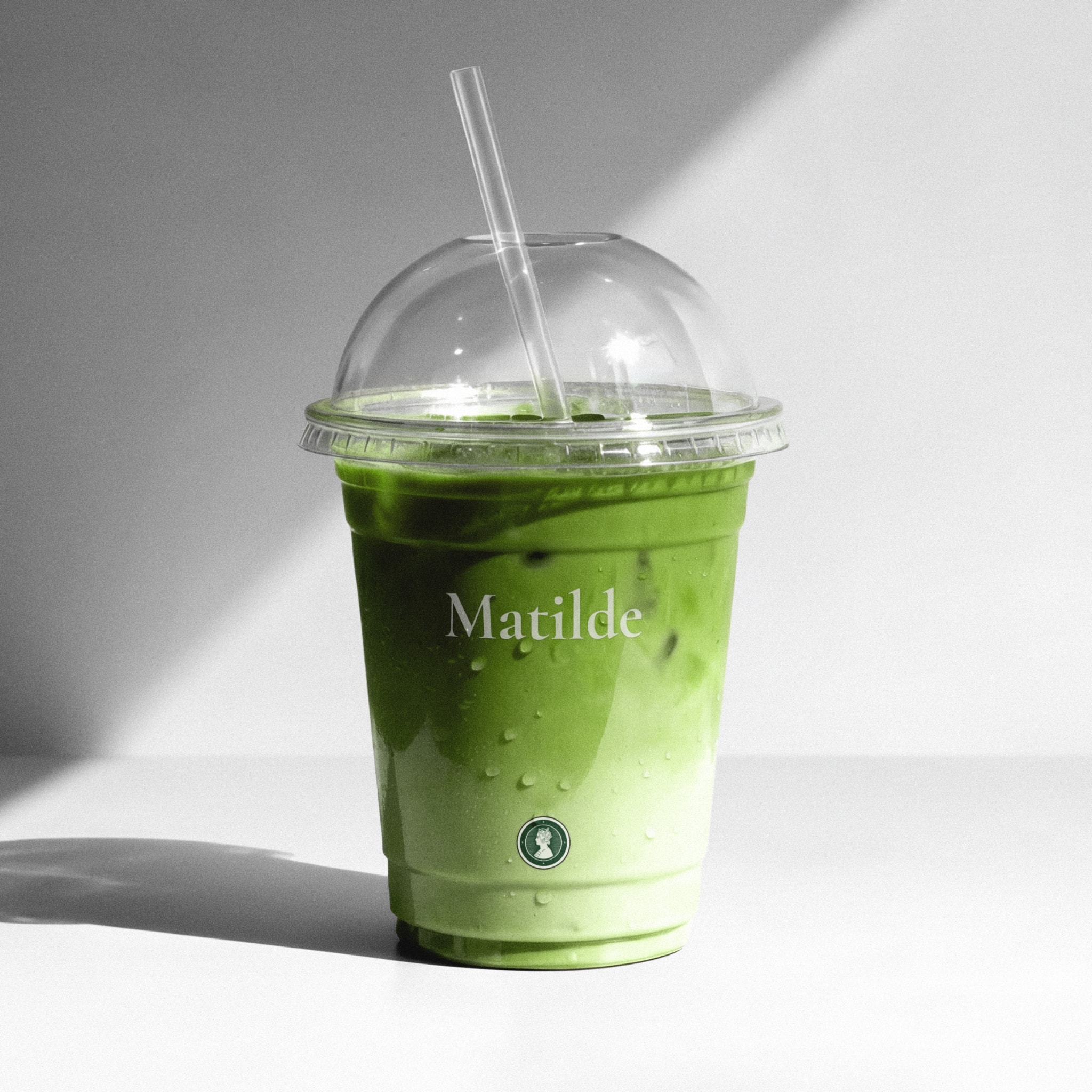 An iced matcha in a cup with the Matilde wordmark and seal