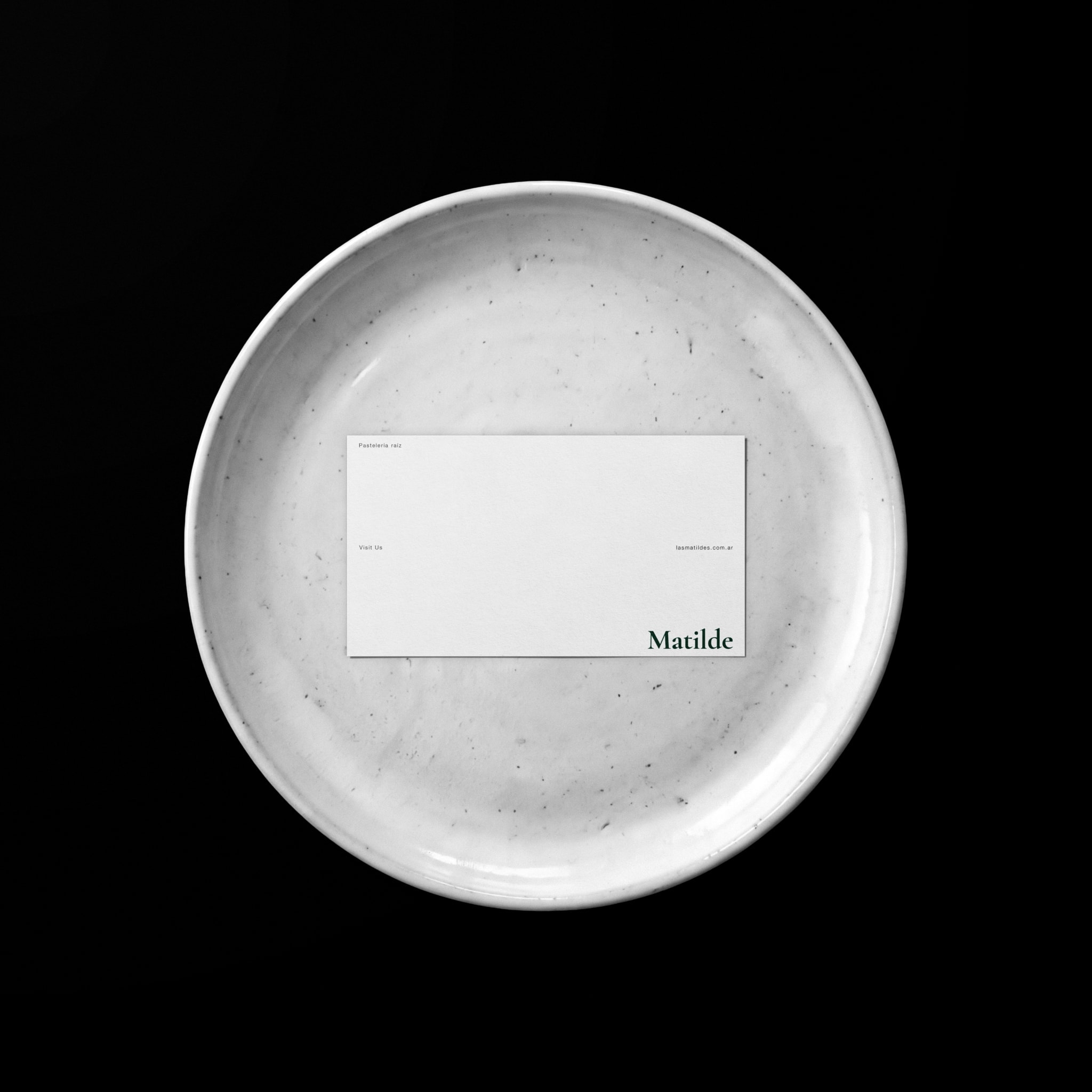 A white card with the wordmark on a stone plate