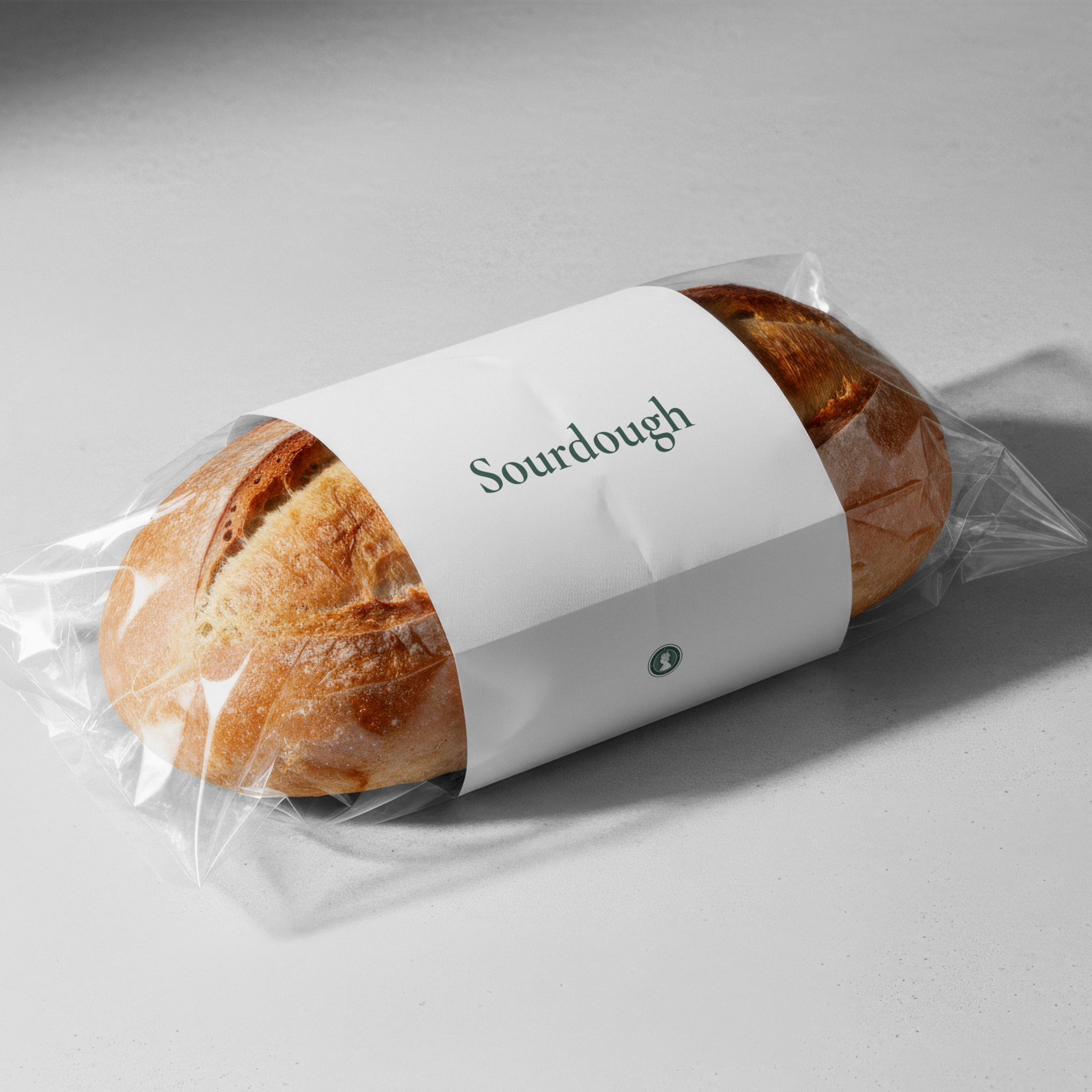 A sourdough loaf in a paper band that reads Sourdough